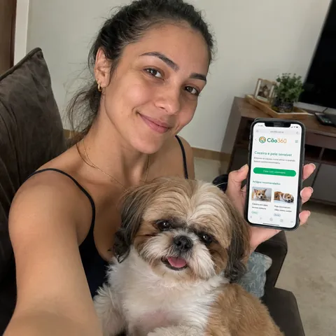 Tutor mostrando o Cão360 ao lado do seu cão